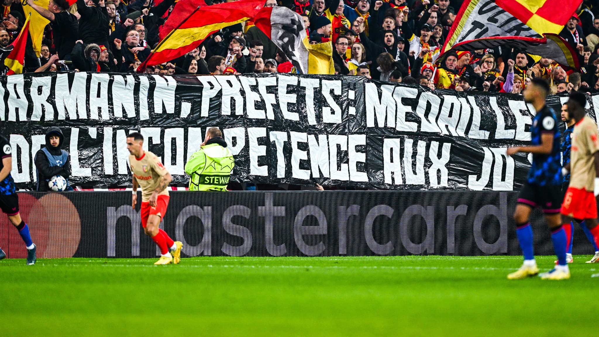 La banderole des fans lensois contre Gérald Darmanin lors de Lens-Séville, le 12 décembre 2023 La banderole des fans lensois contre Gérald Darmanin lors de Lens-Séville, le 12 décembre 2023
