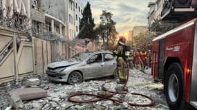 Un pompier devant des immeubles détruits après des frappes israéliennes à Téhéran, en Iran, le 13 juin 2025
