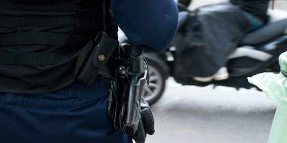 Un policier muni d'une arme. (Photo d'illustration).