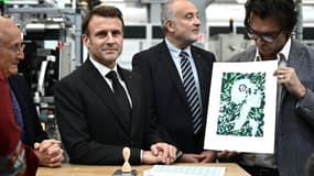 Le président français Emmanuel Macron, flanqué du PDG du groupe "La Poste" Philippe Wahl (à gauche) et du président de Philaposte Paul Dworkin (au centre), est présenté par l'illustrateur français Olivier Balez (à droite) le nouveau visage de Marianne qui sera représenté sur les timbres français de La Poste à l'imprimerie nationale de timbres Philaposte lors d'une cérémonie de dévoilement à Boulazac, dans le sud-ouest de la France, le 7 novembre 2023. 