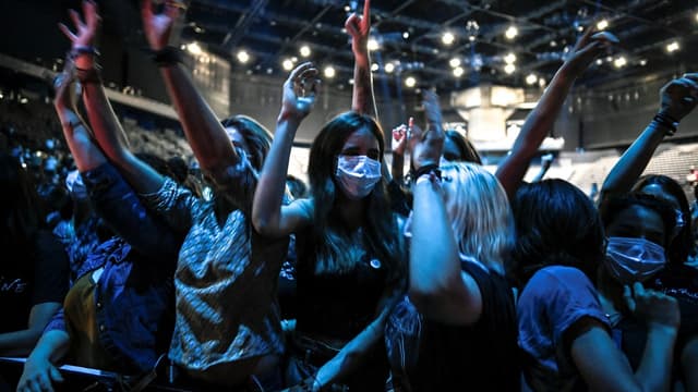 Les gens applaudissent lors d'un concert du DJ français Etienne de Crecy et du groupe pop Indochine à l'AccorHotels Arena de Paris le 29 mai 2021.