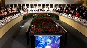 Nicolas Sarkozy et le Premier ministre finlandais Mari Kiviniemi, sur ècran, à l'occasion d'une réunion du 8e sommet Asie-Europe. Le président français a appelé lundi à la construction d'un nouvel ordre monétaire mondial susceptible de remédier aux déséqu