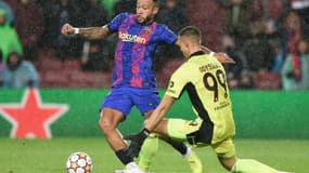 L'attaquant néerlandais de Barcelone, Memphis Depay, tente de dribbler le gardien grec de Benfica, Odisseas Vlachodimos, lors de leur match de groupes de la Ligue des Champions, le 23 novembre 2021 au Camp Nou