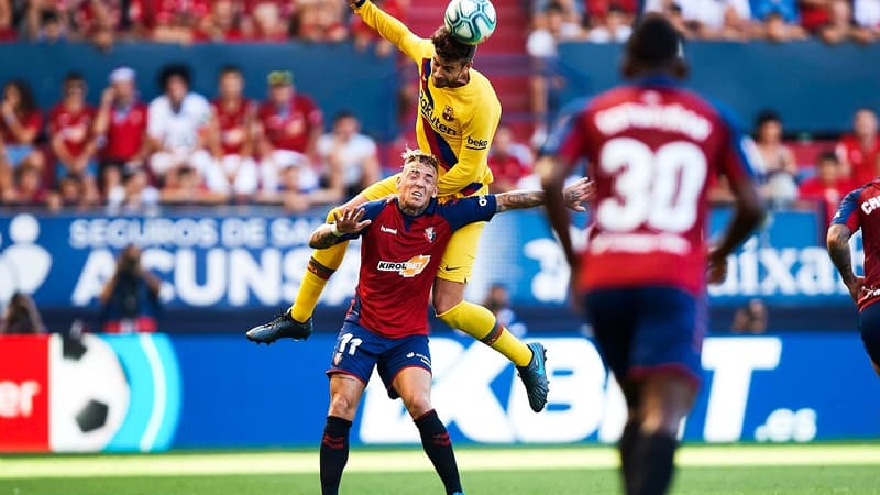 Gerard Piqué du FC Barcelone, le club qui paye le mieux en Europe, domine Brandon Thomas, joueur d'Osasuna, club qui paye le moins en Espagne
