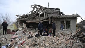 Des habitants cherchent dans les décombres d'une maison à Velyka Vilshanytsia le 9 mars 2023 en Ukraine après un bombardement russe.