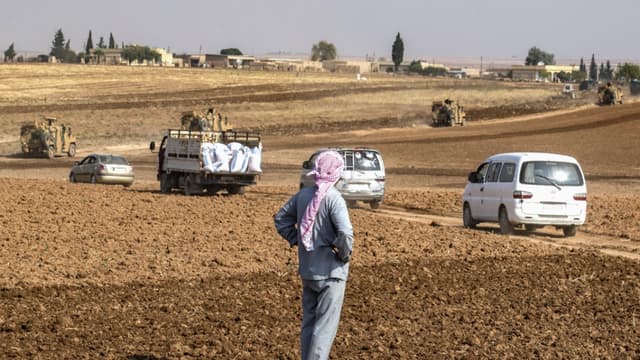 Un homme regarde les patrouilles de véhicules militaires turques, au nord-est de la Syrie dans la province d'Hasakek, le 1er novembre 2019