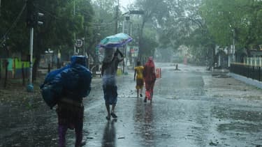 Des résidents marchent jusqu'à un abri avant l'arrivée prévue du cyclone Amphan à Digha, au Bengale occidental, le 20 mai 2020.