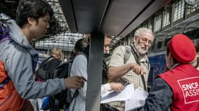 Gare de Lyon, les passagers cherchent à s'orienter auprès des "gilets rouge" de la SNCF.