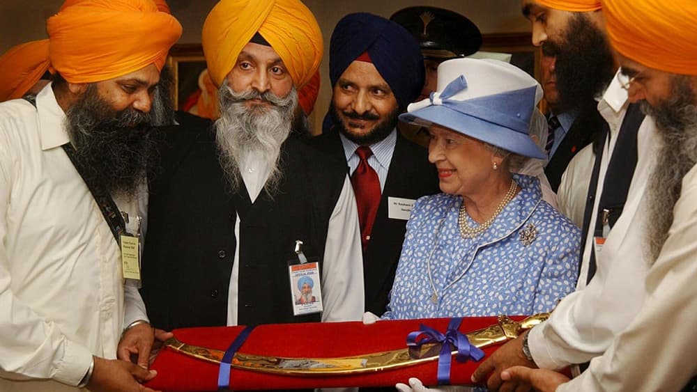 La reine Elizabeth II recevant en 2002 un sabre cérémonial de la communauté Sikh de Leicester en Grande Bretagne.