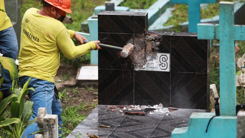Un détenu en train de détruire une tombe portant des symboles faisant allusion au gang Mara Salvatrucha (MS-13) dans un cimetière de Santa Tecla, au Salvador, le 3 novembre 2022.