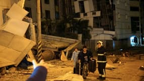Deux personnes sont escortées par des sauveteurs depuis l'hôtel Marshal endommagé à Hualien, dans l'est de Taiwan, dans la nuit du 6 au 7 février 2018, après un violent séisme qui a frappé l'île