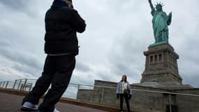 Des touristes devant la statue de la Liberté, à New York