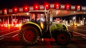 Des agriculteurs bloquent l'autoroute A10 avec des tracteurs, près des barrières de péage du Péage de Saint-Arnoult-en-Yvelines au sud-ouest de Paris, le 26 janvier 2024