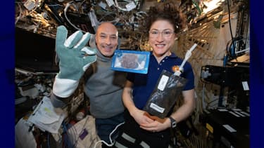 Luca Parmitano et Christina Koch avec le premier cookie cuit dans l'espace et du lait, à bord de la Station spatiale internationale.