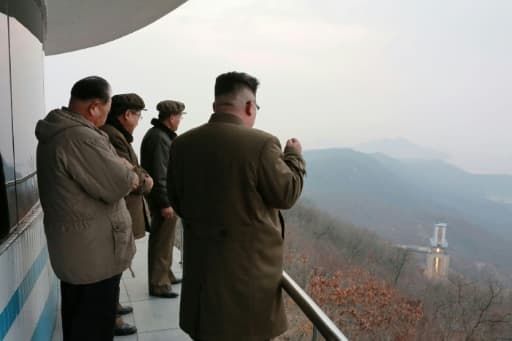 Photo non datée fournie le 19 mars 2017 par l'agence officielle nord-coréenne Kcna du leader Kim Jong-Un (d) assiste à un essai au sol d'un moteur très puissant sur le site de lancement de Sohae