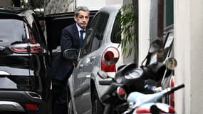 L'ancien président français Nicolas Sarkozy sort d'un véhicule alors qu'il rentre chez lui à Paris, le 13 octobre 2025.