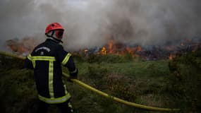 Un pompier lors d'un feu de forêt dans les Monts d'Arrée, en Bretagne, le 19 juillet 2022. 
