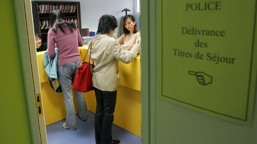 Des personnes viennent chercher leur titre de séjour, le 25 octobre 2004 à Paris au centre d'accueil et d'intégration des nouveaux immigrés.