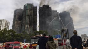 Des habitants de Hong Kong devant les immeubles en feu, le 27 novembre 2025