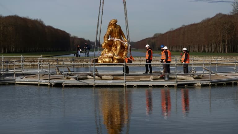 Des employés replacent la statue-fontaine d'Apollon dans son bassin à Versailles, dans les Yvelines, le 15 février 2024