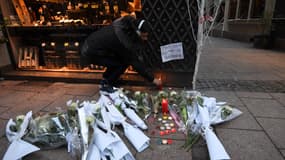 Un homme allume une bougie en hommage aux victimes de l'attaque perpétrée mardi soir à Strasbourg.