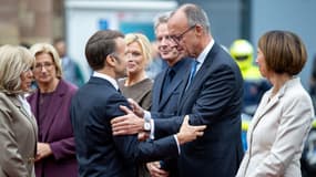 Emmanuel Macron salue le chancelier Friedrich Merz à son arrivée devant la Chancellerie de la Sarre à Sarrebruck lors des célébrations des 35 ans de l'unité allemande, le 3 octobre 2025.