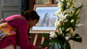Une femme écrit un message de condoléance à côté du portait de Mauranne, à Eguilles, le 2 octobre 2017