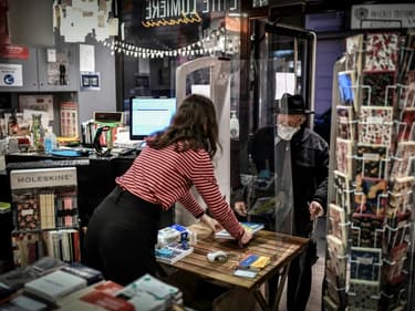 Un client retire un livre précommandé dans une libraire de Paris le 31 octobre 2020