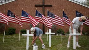 Deux habitants disposent des croix devant une église en hommage aux soldats tués de Fort Hood.