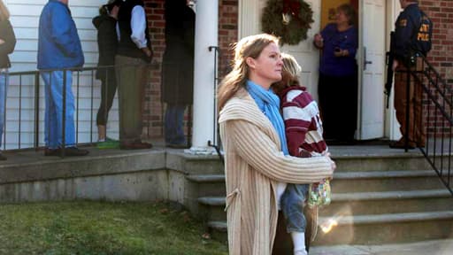 Une femme étreint un enfant peu après la fusillade de Newtown, le 14 décembre 2012