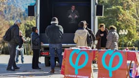 Des passants écoutent l'hologramme de Jean-Luc Mélenchon (LFI) dans un holovan, le 6 février 2019 à Sospel, dans le sud de la France. 