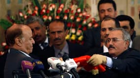 Le nouveau président yéménite Abd-Rabbou Mansour Hadi (à gauche) a officiellement pris ses fonctions lundi des mains de son prédécesseur Ali Abdallah Saleh (à droite). Il déclaré que le Yémen traversait "une phase complexe et difficile" après 33 ans de po