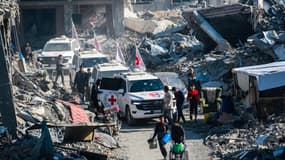 Un convoi de la Croix-Rouge traverse des décombres de bâtiments alors qu'il arrive pour la remise de l'otage israélien Agam Berger à Jabalia, le 30 janvier 2025, dans le cadre de leur troisième échange d'otages et de prisonniers.