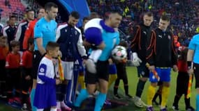 L'arbitre de Bologne-Shakhtar Donetsk (0-0) porte l'enfant porteur de balle, frigorifié par la pluie, le 18 septembre 2024