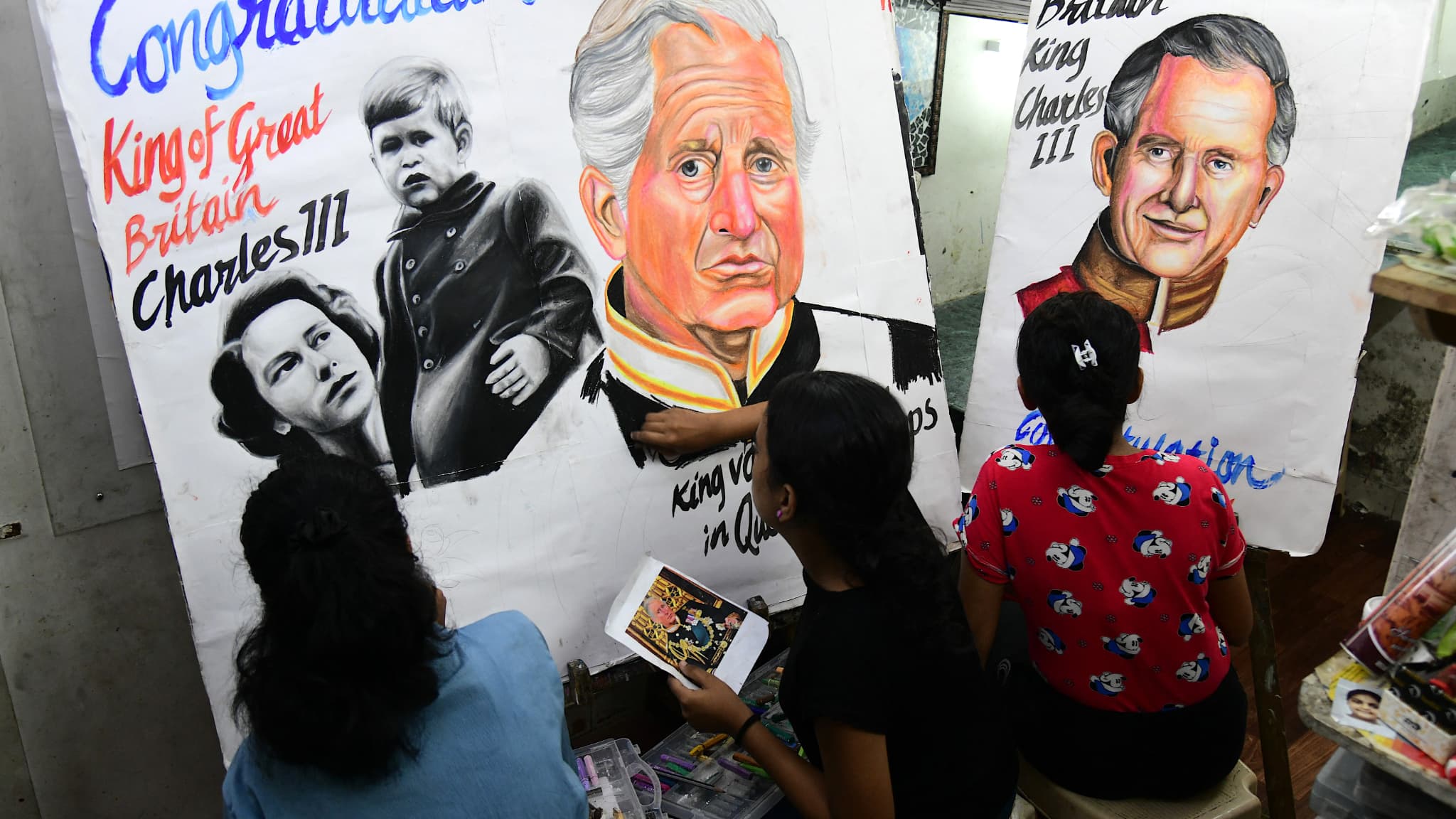 Des étudiants d'une école d'art apportent la touche finale aux peintures réalisées pour féliciter le prince Charles III de Grande-Bretagne lors de son accession au trône, à Mumbai, le 11 septembre 2022. 