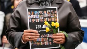 Une femme tient une pancarte sur laquelle figurent les portraits des otages détenus lors d'un rassemblement sur l'esplanade du Trocadéro, dans le centre de Paris, le 10 octobre 2025.