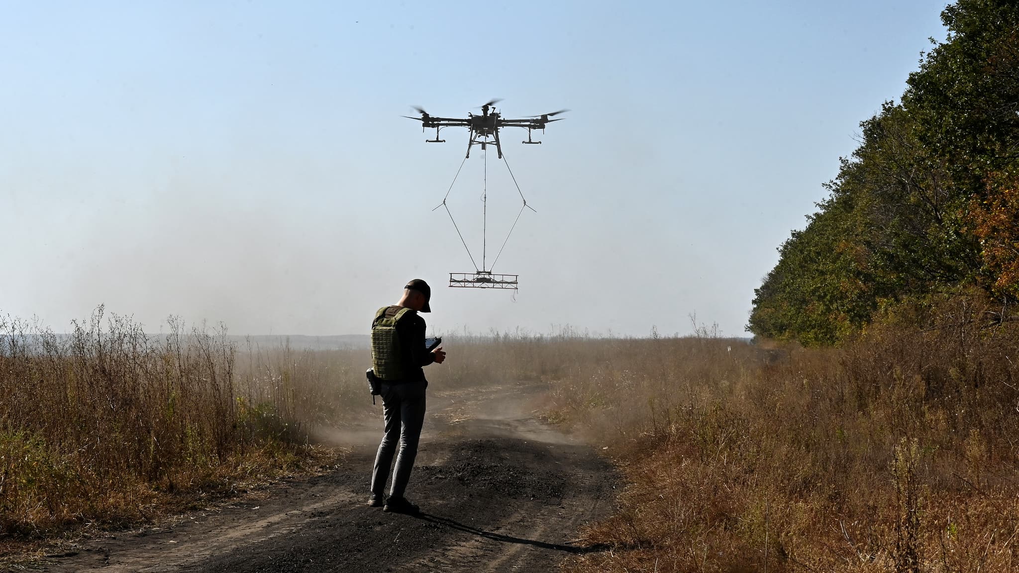Un Ukrainien contrôle le vol d'un drone transportant un détecteur de métaux pour rechercher des mines près de la ville de Derhachi, dans la région de Kharkiv, le 1er octobre 2023.