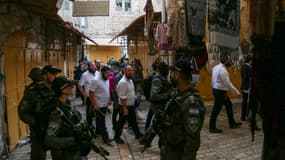 Des colons israéliens, sous la protection de soldats, se déplacent dans la vieille ville d'Hébron, en Cisjordanie, le 9 août 2025, dans le but de chasser les Palestiniens.