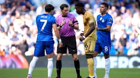 Darren England explique à Pedro Neto et Marc Guehi qu'il va consulter les écrans de le VAR lors de Chelsea-Crystal Palace en Premier League le 17 août 2025