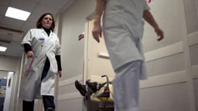 Des infirmières passent devant un patient sur un brancard, le 9 novembre 2010, à l'hôpital Tenon à Paris. Les salariés du service des urgences de l'hôpital sont en grève depuis six semaines pour protester contre leurs conditions de travail.
