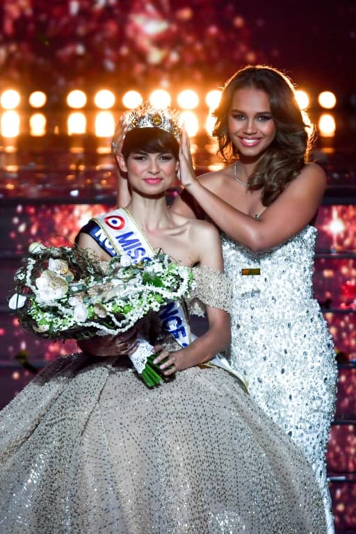 Miss Nord-Pas-de-Calais, Eve Gilles (L), est couronnée Miss France 2024 par Miss France 2023 Indira Ampiot (D), à Dijon, le 16 décembre 2023