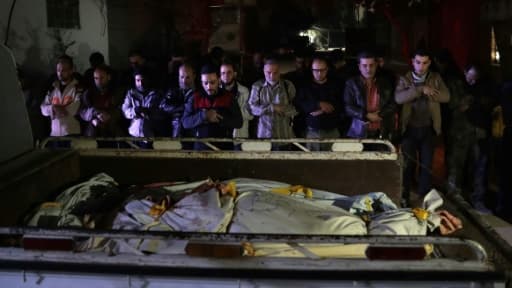 Des Syriens prient devant les corps de victimes d'une frappe aérienne du gouvernement, le 3 avril 2017 dans la ville rebelle de Douma, à l'est de Damas