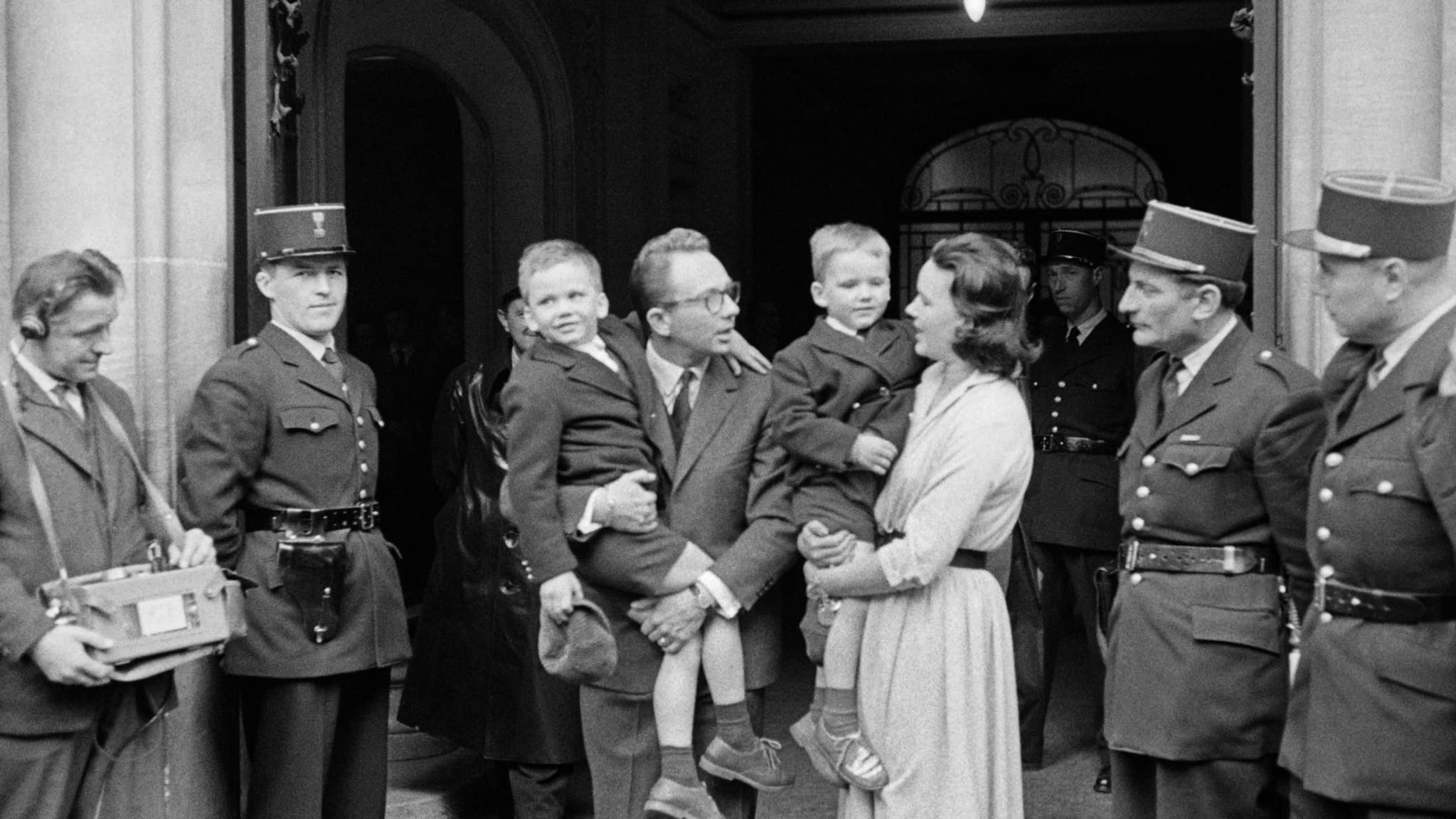 Photo prise le 12 avril 1960 à Paris, montrant l'enfant Eric Peugeot (2ème à droite) dans les bras de sa mère Colette alors qu'ils quittent le commissariat avec le père Roland Peugeot tenant dans ses bras le petit frère Jean-Philippe.