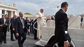 Le pape escorté de son impressionnant service de sécurité, le 16 septembre 2015, place Saint-Pierre au Vatican.