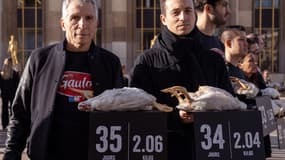 Nagui (à gauche) et Hugo Clément (à droite) détiennent des poulets morts avec des banderoles indiquant leur âge et leur poids au moment de leur mort lors d'une manifestation organisée par l'association française de défense des droits des animaux L214 sur la place des droits de l'homme du Trocadéro à Paris, le Le 15 février 2024, pour sensibiliser et dénoncer l'utilisation de poulets génétiquement manipulés par l'entreprise agroalimentaire française "Le Gaulois" à Paris.