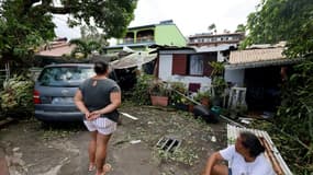 Des habitantes devant une maison dévastée par le cyclone Garance à Sainte-Anne, sur l'île de La Réunion, le 1er mars 2025