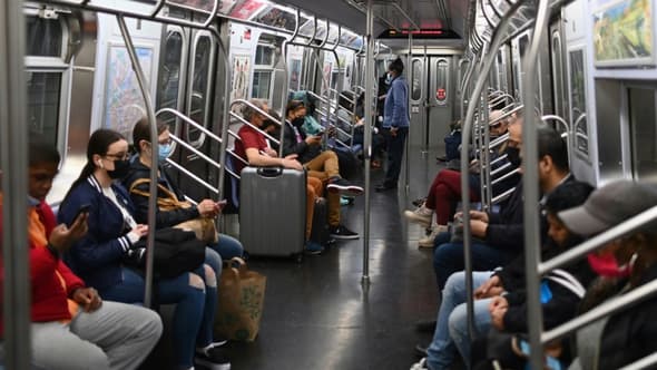 Des New Yorkais dans le métro, le 13 avril 2022, au lendemain de l'attaque à l'arme à feu dans un train, qui a fait 23 blessés, dont 10 par balles