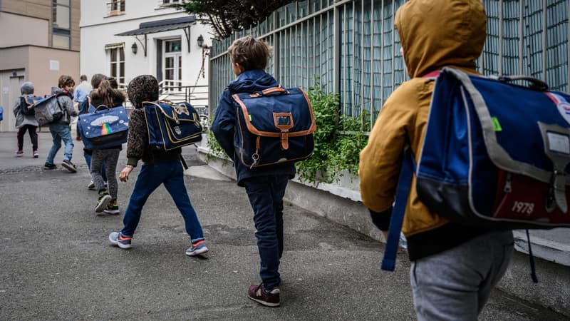 Photo d'élèves entrant en classe en respectant des mesures de distanciation, le 12 mai à Paris