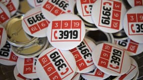 Des badges avec le logo du numéro d'appel d'urgence (39 19) créé pour lutter contre les violences conjugales. Septembre 2019, à Paris. 