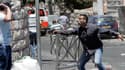 Un policier israélien en tenue civile pointe son arme vers un Palestinien, tandis que ses collègues arrêtent des manifestants, au cours de heurts ayant éclaté après la traditionnelle prière du vendredi. Jérusalem, le 25 juillet.